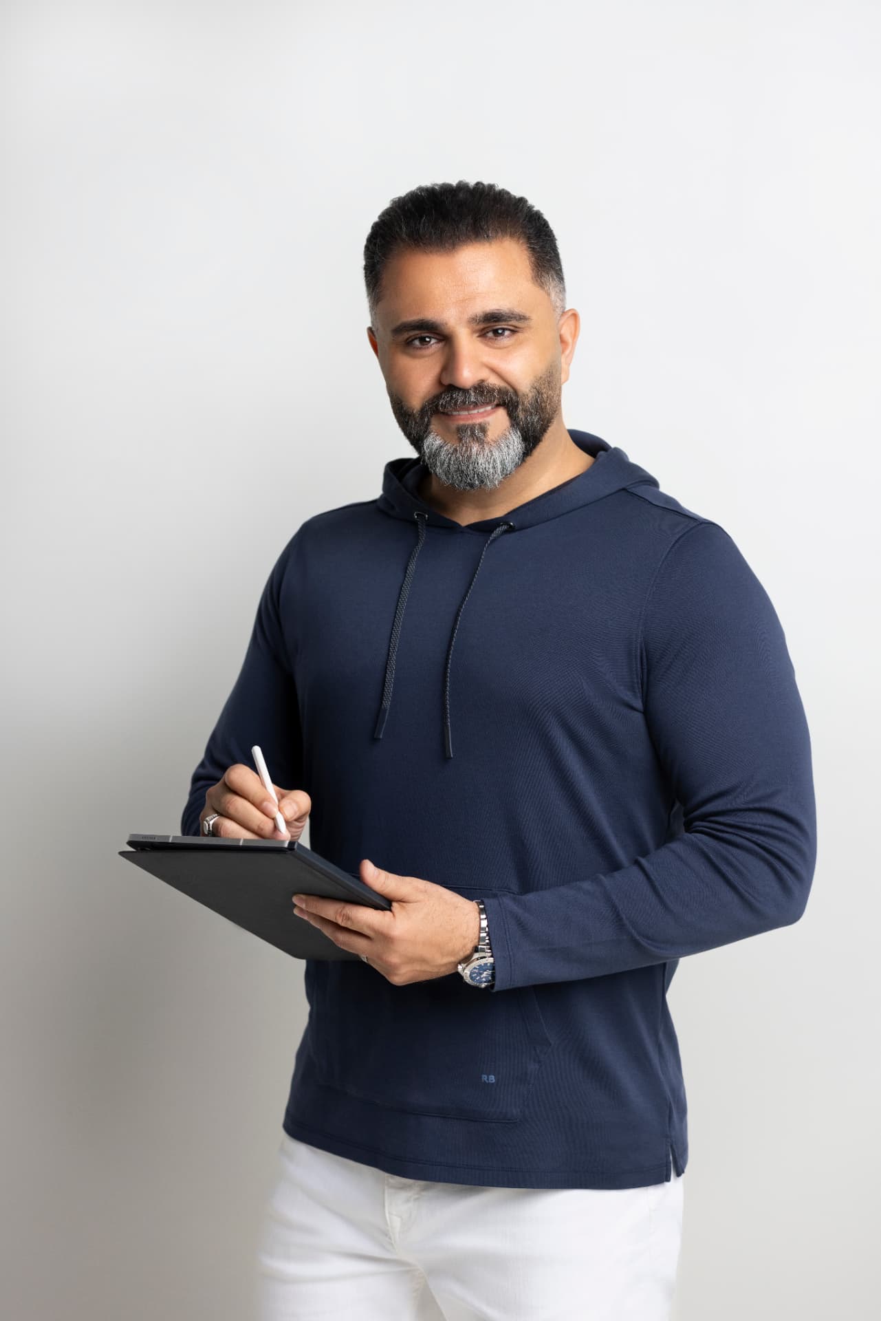 Alaa Hassan writing on a tablet in a navy hooded top